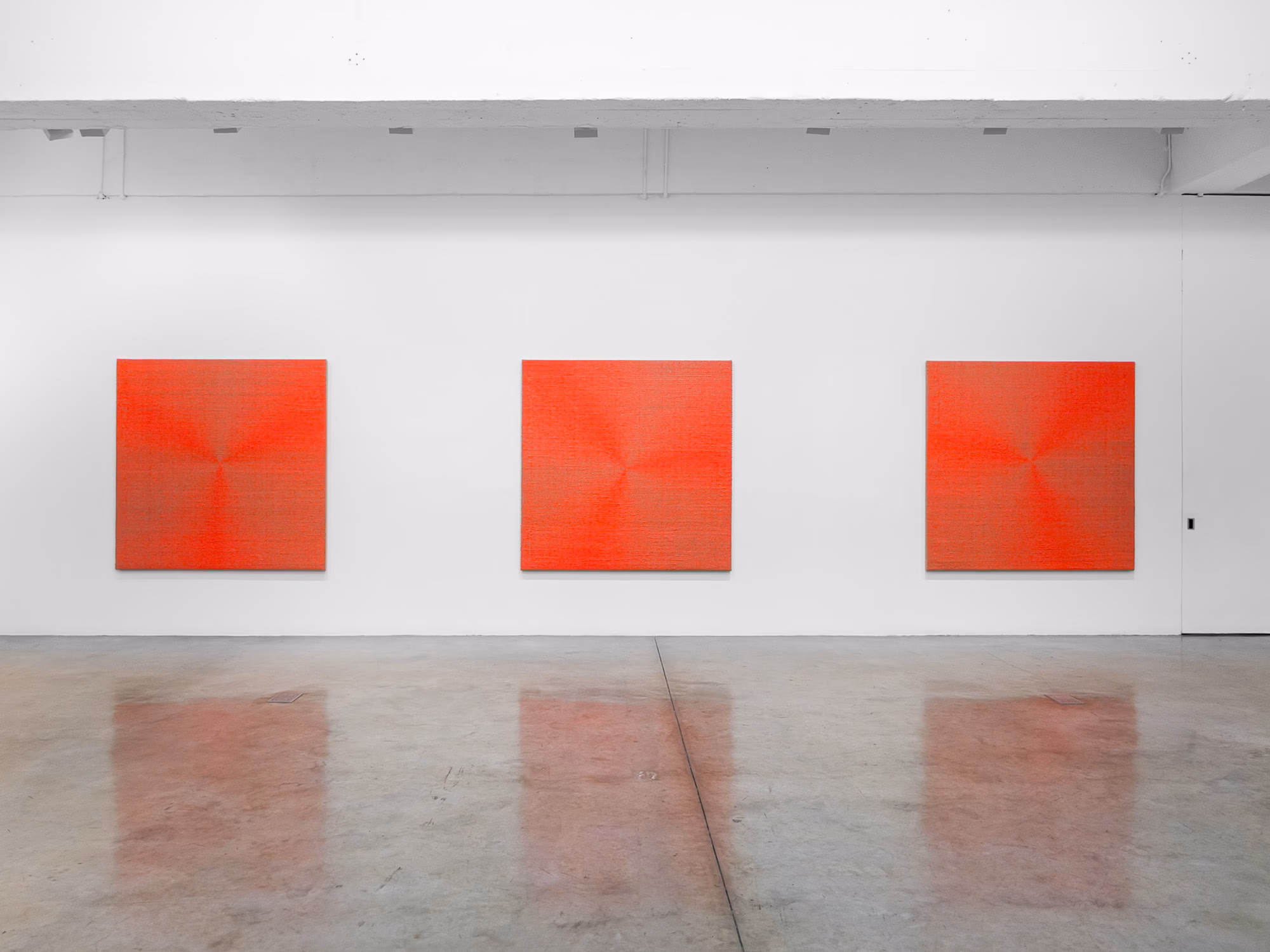 Art catalog open to spread of two woven textile works with fringe
